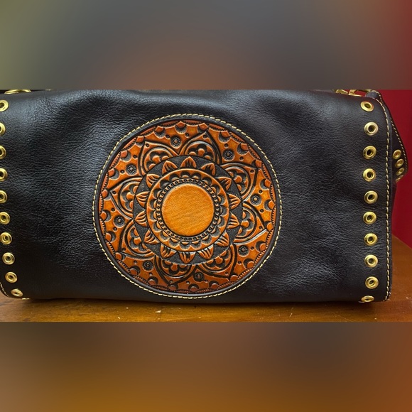 Black leather cross body purse with orange colored medallion on front. - Picture 10 of 14